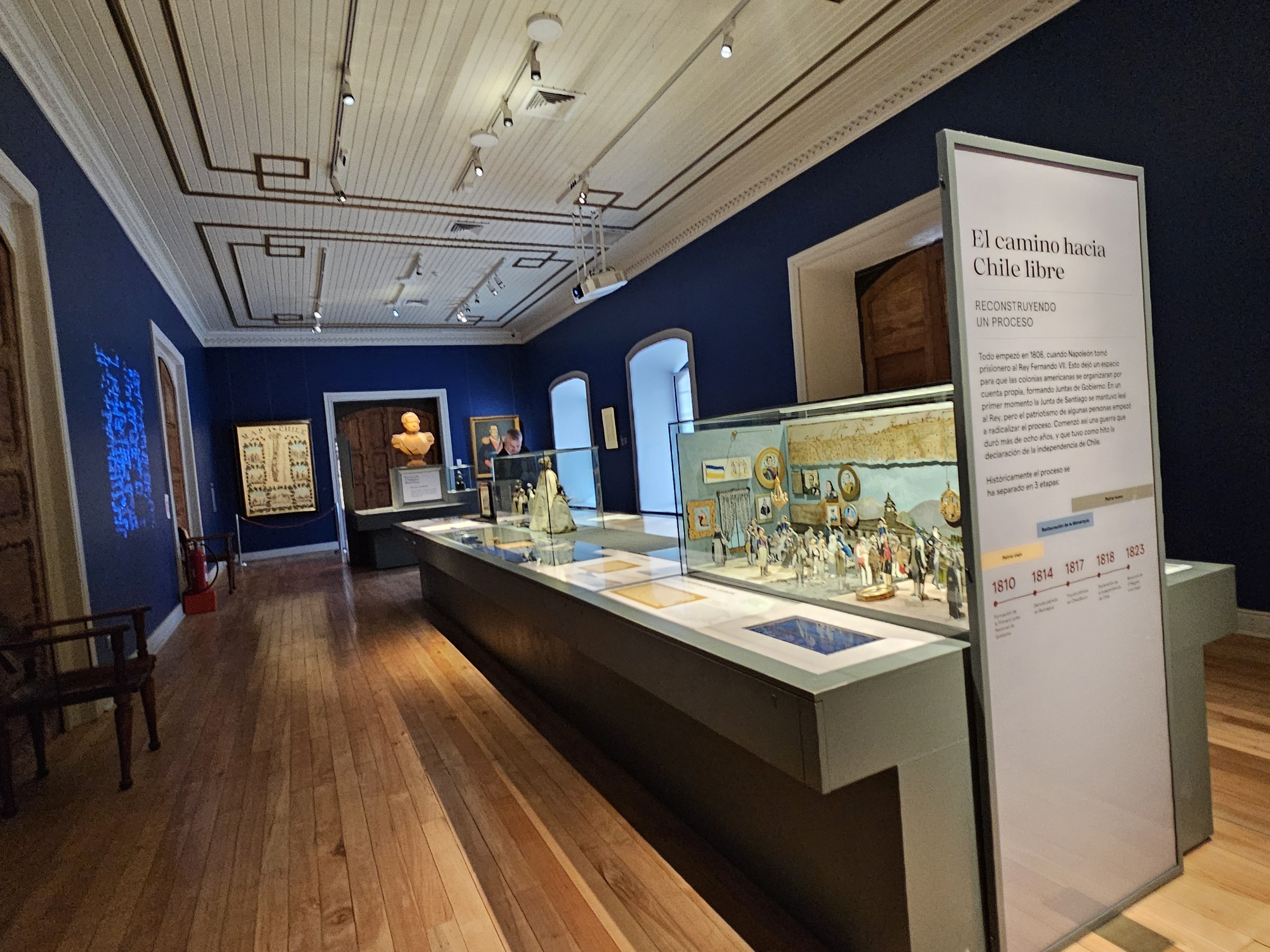 Fotografía de un mesón central del museo con objetos relevantes y un afiche que introduce lo expuesto